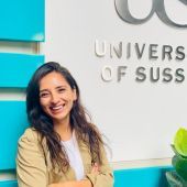 Female student leaning on a wall in University of Sussex